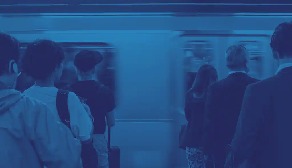 persone che stanno aspettando che la metro si fermi per prenderla